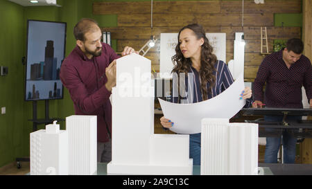 Group of architects working on 3D printed models of buildings. Architecture and design Stock Photo