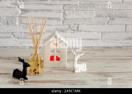 Candles and Christmas decoration on white wooden table with bokeh lights over brick wall. Sweet hime, Christmas time. Stock Photo