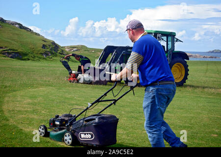 Cutting the putting greens, on the 18 hole golf course, in preparation for the Iona Open.This is one of Scotlands most scenic and natural golf courses