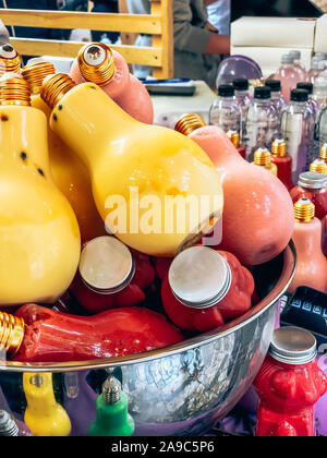Assortment of fresh healthy fruit smoothie drinks in funny lamp form bottles on showcase of a street farmer market cafe. Small family business concept Stock Photo
