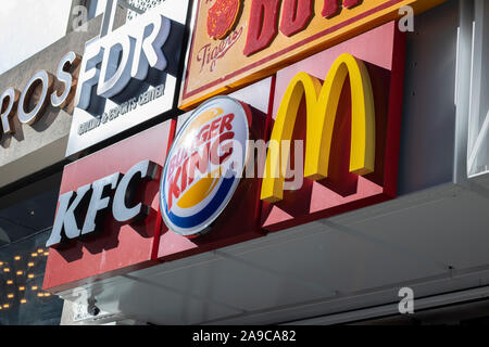 Istiklal, Turkey - October-13,2019: McDonalds, Kfc, Burger King logos hanging on the sign on the wall of the building together. Taken from the sidelin Stock Photo