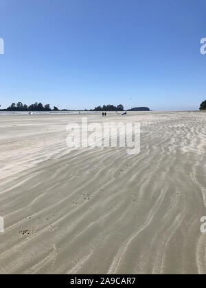 Windy Beach with Textured Sand and Big Blue Sky and Kite Boarders Stock Photo