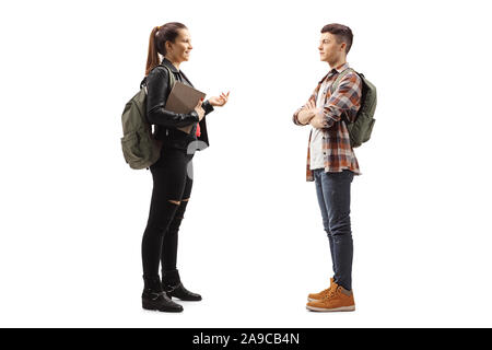 Full length profile shot of a female student talking to a male student isolated on white background Stock Photo