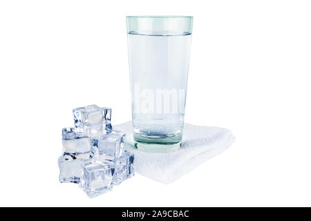 Glass of water next to lie ice cubes. Stock Photo