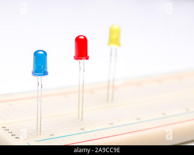 three color leds in breadboard isolated in white background. Close up. Selective focus. Stock Photo