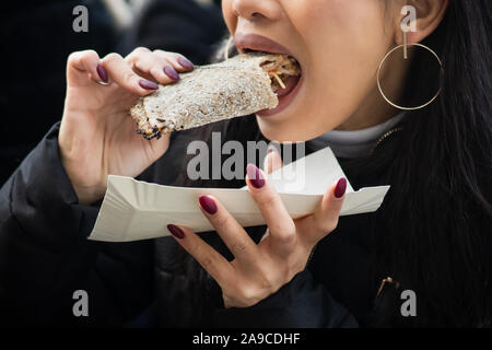 Woman with beautiful nails eating food voraciously. Stock Photo