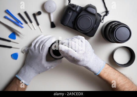 High Angle View Of Man Cleaning Camera Lens Element Stock Photo