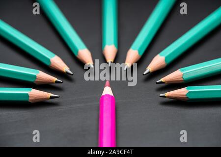Pink Colored Pencil Surrounded With Green Lead Pencils On Black Chalkboard Stock Photo