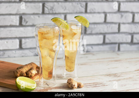 Fresh Ginger Ale with lime and ice or Kombucha in Bottle - Homemade lemon and ginger organic probiotic drink, copy space. Stock Photo