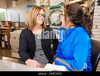 The general manager of Interstate Trucksource checks in with a new employee, May 7, 2018, in Romulus, Michigan. Stock Photo