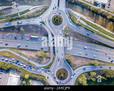 Highway interchange junction with traffic aerial top down view photography from drone with vehicles driving on freeway, roundabout and ramp lanes, tra Stock Photo