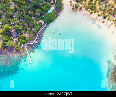 Aerial view of tropical beach at island hotel resort with blue sea water and coconut palm trees, beautiful summer vacation holidays destination, drone Stock Photo