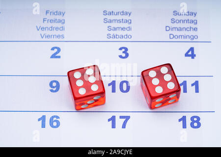 An Overhead View Of Two Transparent Red Dice On Calendar's Date Stock Photo