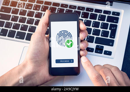Secure access granted by valid fingerprint scan, cyber security on internet with biometrics authentication technology on mobile phone screen, person h Stock Photo