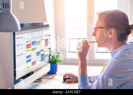 Person using calendar on computer to improve time management, plan appointments, events, tasks and meetings efficiently, improve productivity, organiz Stock Photo