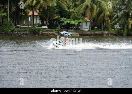 Happy young couple enjoying and having fun riding on a jet ski. Tropical coast of Sri Lanka Stock Photo