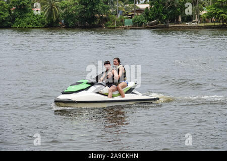 Happy young couple with thumbs up enjoying and having fun riding on a jet ski. Tropical coast of Sri Lanka Stock Photo