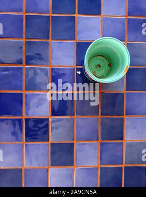 Stylized picture of green mug on table top with square ceramic tiles Stock Photo
