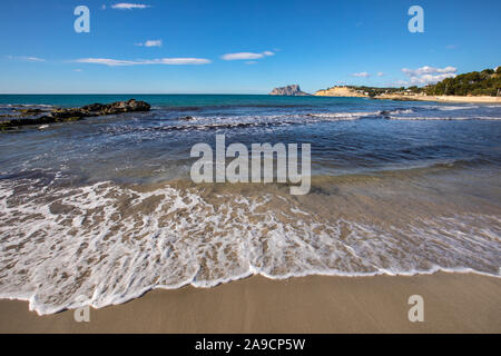 A beautiful view from the beach in Moraira, looking towards Calpe Rock and the town of Calpe in the Costa Blanca region of Spain. Stock Photo