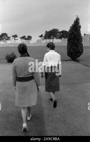 Womens prison 1980s UK. Prisoner and prison officer walk, exercising in grounds of HM Prison Styal Wilmslow Cheshire England 1986. HOMER SYKES Stock Photo