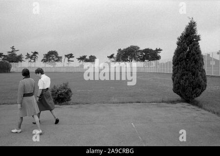 Womens jail 1980s UK. Prisoner and guard walk, exercising in grounds of HM Prison Styal Wilmslow Cheshire England 1986. HOMER SYKES