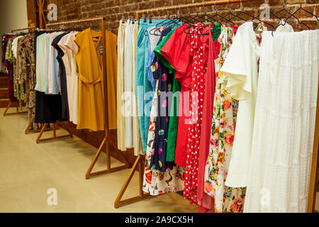Colorful collection of women's clothes hanging on a rack. Stock Photo