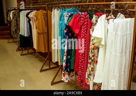 Colorful collection of women's clothes hanging on a rack. Stock Photo