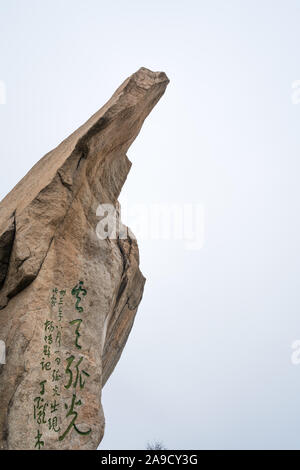 Huashan, China -  August 2019 : Huge tall rock formation with chinese characters inscription painted on it on the scenic mountain trail to the North a Stock Photo