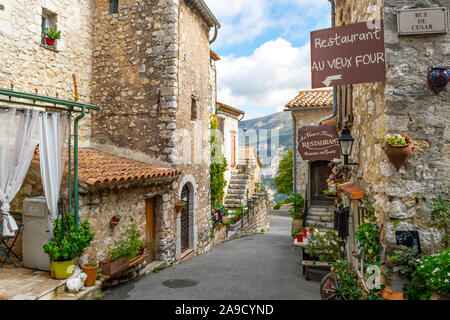 A typical picturesque street of shops and cafes in the medieval hilltop village of Gourdon, in the Alpes-Maritimes area of the French Riviera. Stock Photo