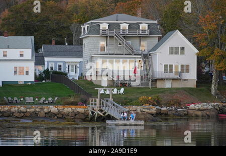 Boothbay Harbor, ME / USA - October 19, 2019: Elderly caucasian couple lounging outside on their dock to watch the sun set Stock Photo