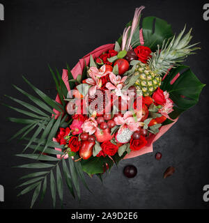 Unusual gift in the form of a bouquet of flowers and fruits. View from above Stock Photo