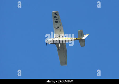 Cessna A152 Aerobat single engined light aircraft  G-BZEA flying overhead, set against a blue sky Stock Photo