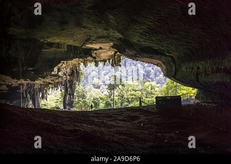 Person standing in entrance to Niah cave, Malaysia Stock Photo