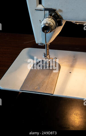 Close view of Sewing machine arm and needle from the front Stock Photo
