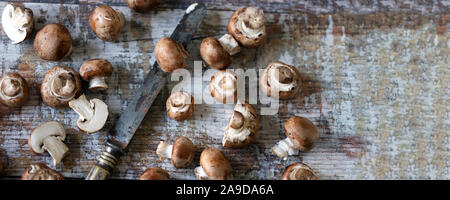 Royal champignons and knife on a wooden surface. Brown champignons. Selective focus. Macro. Stock Photo