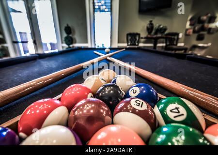 Billiard balls are racked on a pool table alongside two pool cues in the clubhouse at Cypress Cove Apartment Homes in Mobile, Alabama. Stock Photo