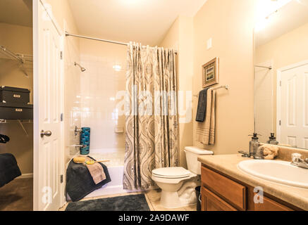 A bathroom sink, toilet, and shower is pictured at Cypress Cove Apartment Homes in Mobile, Alabama. Stock Photo