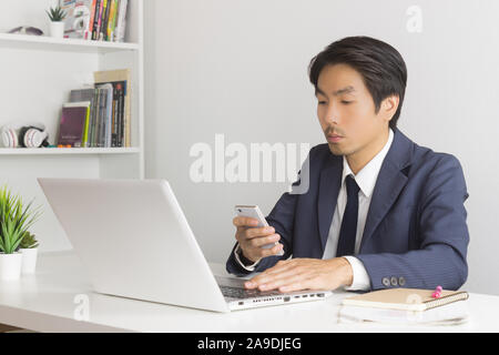 Asian Financial Advisor or Asian Consulting Businessman Sending Message or Chat with Customer. Asian Financial Advisor or Asian Consulting Businessman Stock Photo