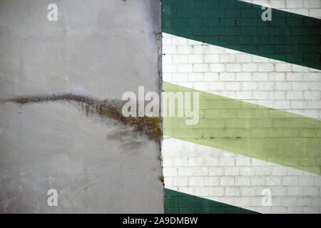 Two house walls side by side with a smooth layer of plaster and painted bricks. Stock Photo