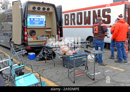 Browns fans tailgate in the infamous Muni-Lot in downtown Cleveland, Ohio prior to the Pittsburgh Steelers Cleveland Browns game at nearby FirstEnergy Stadium.  The cold temperatures, as shown on the television in the back of the van, coupled with the Browns record did not deter fans from filling the lot for the Thursday evening game. Stock Photo