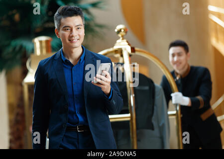 Business man make a phone call at the hotel lobby Stock Photo