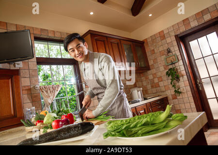 Young man is cooking in the kitchen Stock Photo