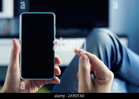 Male hands touching smartphone screen on dark flat with copy space. black screen of the smartphone. blank form for design. pastime with a smartphone i Stock Photo