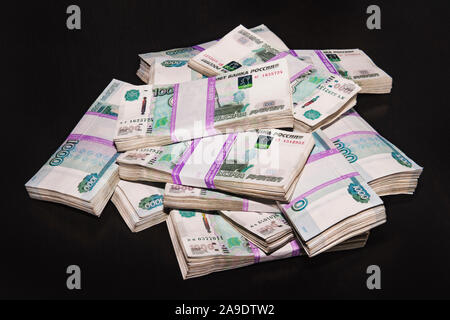 Bank of Russia money tickets are 1000 rubles background. A lot of money laid out in bundles of 100,000 rubles on a black background. Stock Photo