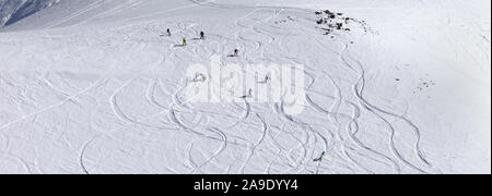 Snowboarders downhill on snowy off piste slope with newly-fallen snow. Panoramic view. Stock Photo