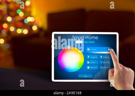 Smart home lights control on a tablet during the holidays with a hand Stock Photo