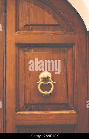 A doorknocker in a closed severe door of woodwork Stock Photo
