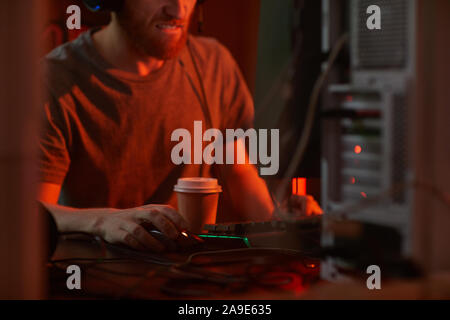 Close-up of computer programmer working till night and drinking coffee at his workplace at office Stock Photo