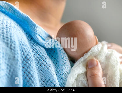 premature newborn baby wrapped in lace blanket , mother holding her child to her chest  represented by a reborn doll; background for copy space and te Stock Photo