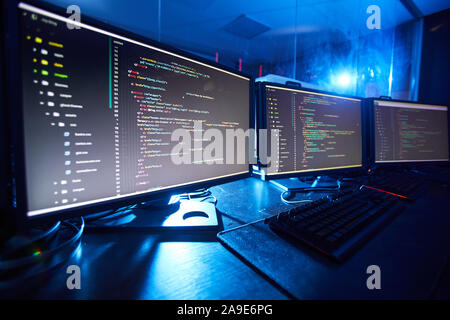 Image of computer monitors updating the software they standing on the table in dark room Stock Photo